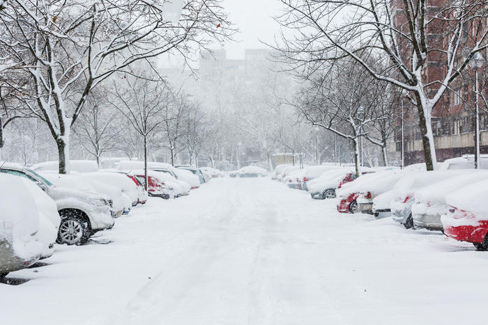 Vehicles parked and covered in snow